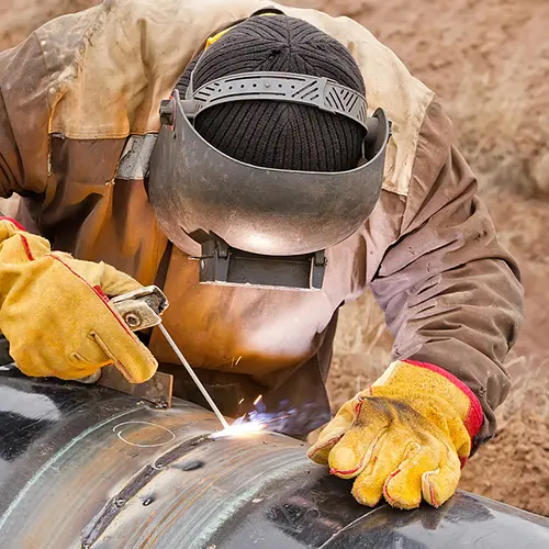 Picture of person with face gear working on a pipeline